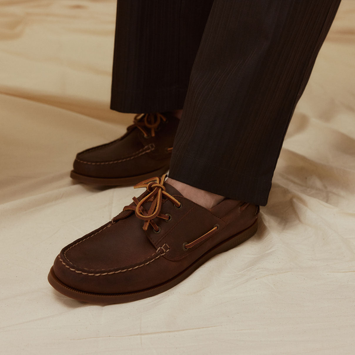 A pair of men's brown boat shoes against a white background